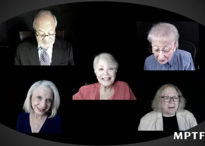 A group of older people are sitting in front of a black background.