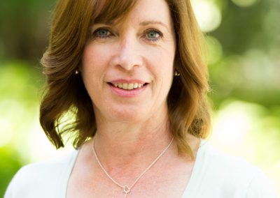 A woman wearing a white shirt and a necklace.