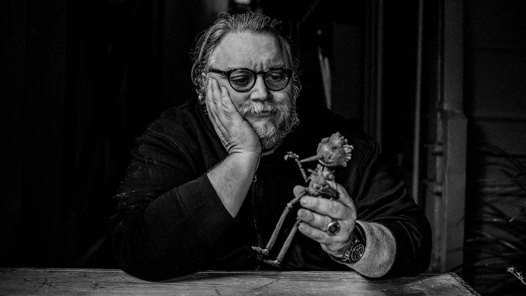 A black and white photo of a man holding a flower.