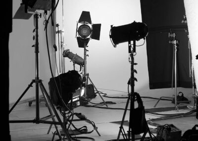 A black and white photo of a studio with lighting equipment.