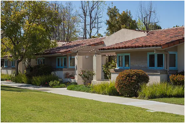 A house with a shingle roof and blue shutters.